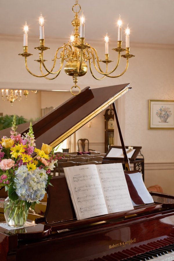 Chapel interior with grand piano and flowers at Warminster, PA funeral home and cremations memorial service room